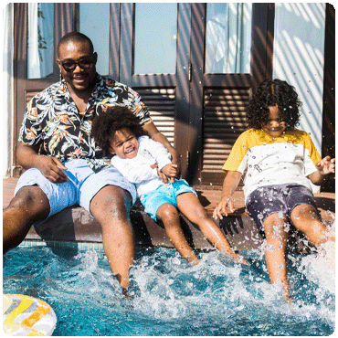 Father and sons splashing in pool